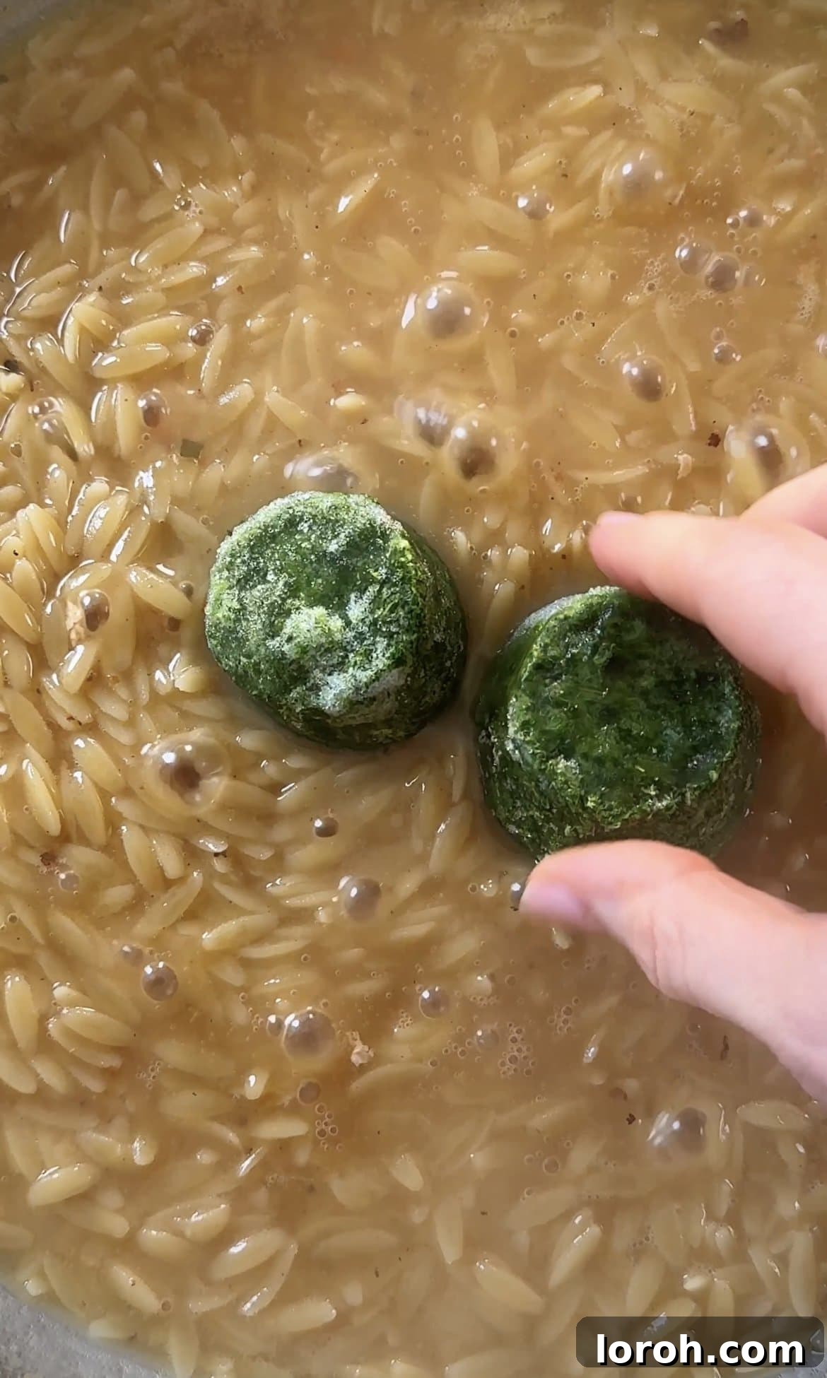 Zesty Lemon Chicken Orzo 9 adding frozen spinach to the cooked orzo, preparing for final additions.