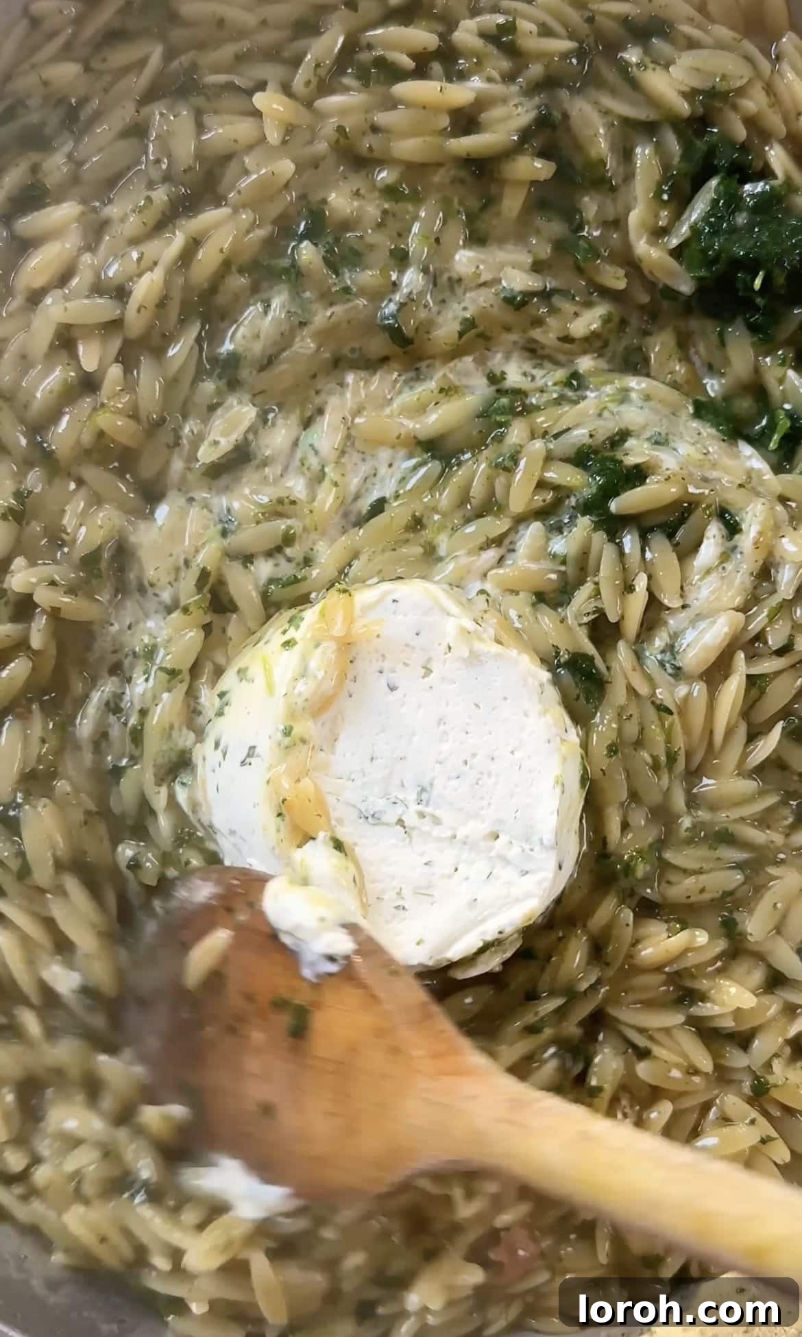 Zesty Lemon Chicken Orzo 10 stirring in creamy Boursin cheese to lemon chicken orzo, creating a rich sauce.