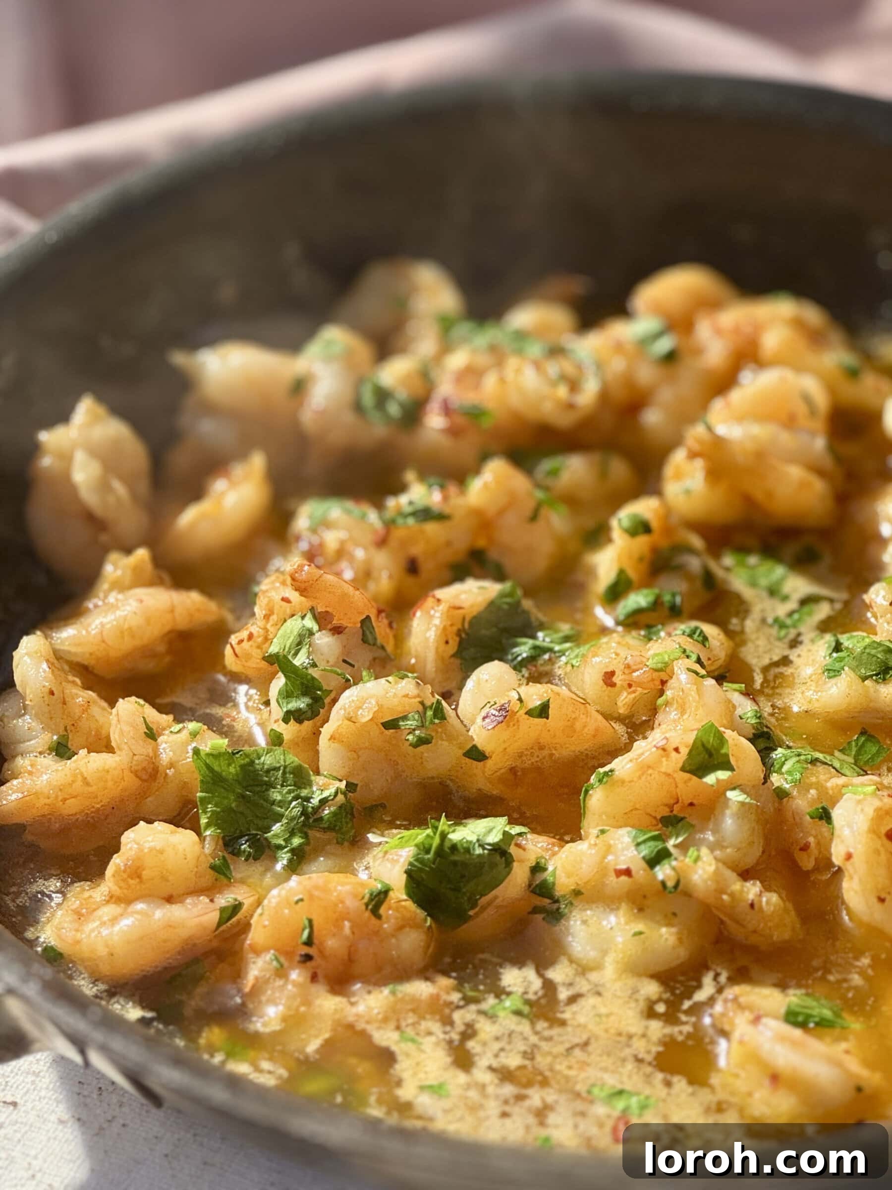 Sizzling Garlic Butter Prawns 12 buttered garlic prawns in frying pan with parsley.