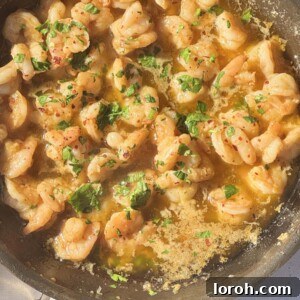 buttered garlic prawns in frying pan with parsley.