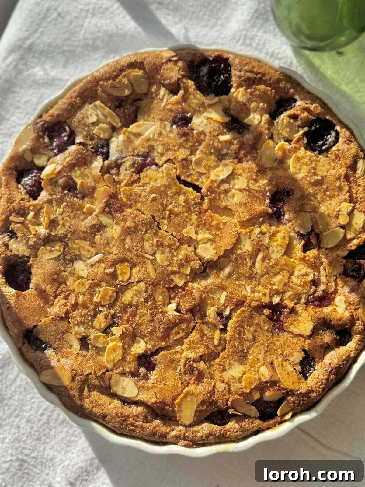 Classic French Cherry Clafoutis 3 A beautifully baked Clafoutis aux Cerises, golden brown and puffed up in a white pie dish.