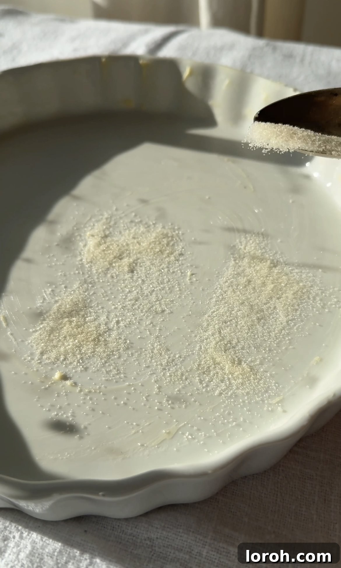 Classic French Cherry Clafoutis 4 Step one: Buttering a pie dish and scattering it with sugar.