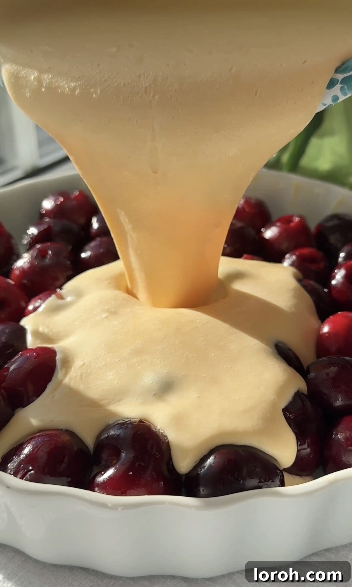 Classic French Cherry Clafoutis 9 Step six: Pouring the smooth batter evenly over the cherries in the pie dish.