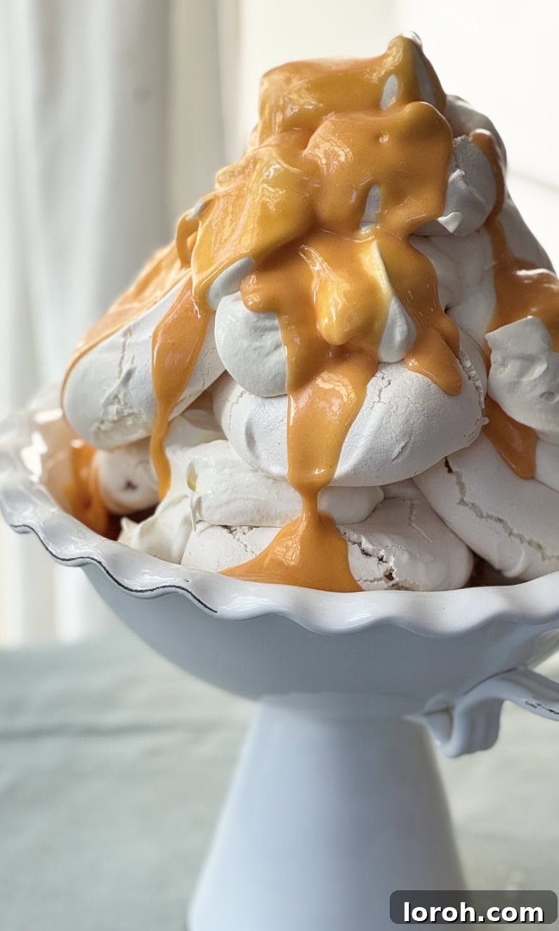 A grand tower of lemon meringues, cream, and lemon curd, adorned with fruit, ready to be served at a special event.
