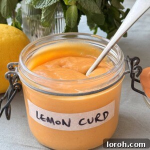 A close-up of the delicious Easy Homemade Lemon Curd, showing its vibrant colour and smooth texture in a glass jar.