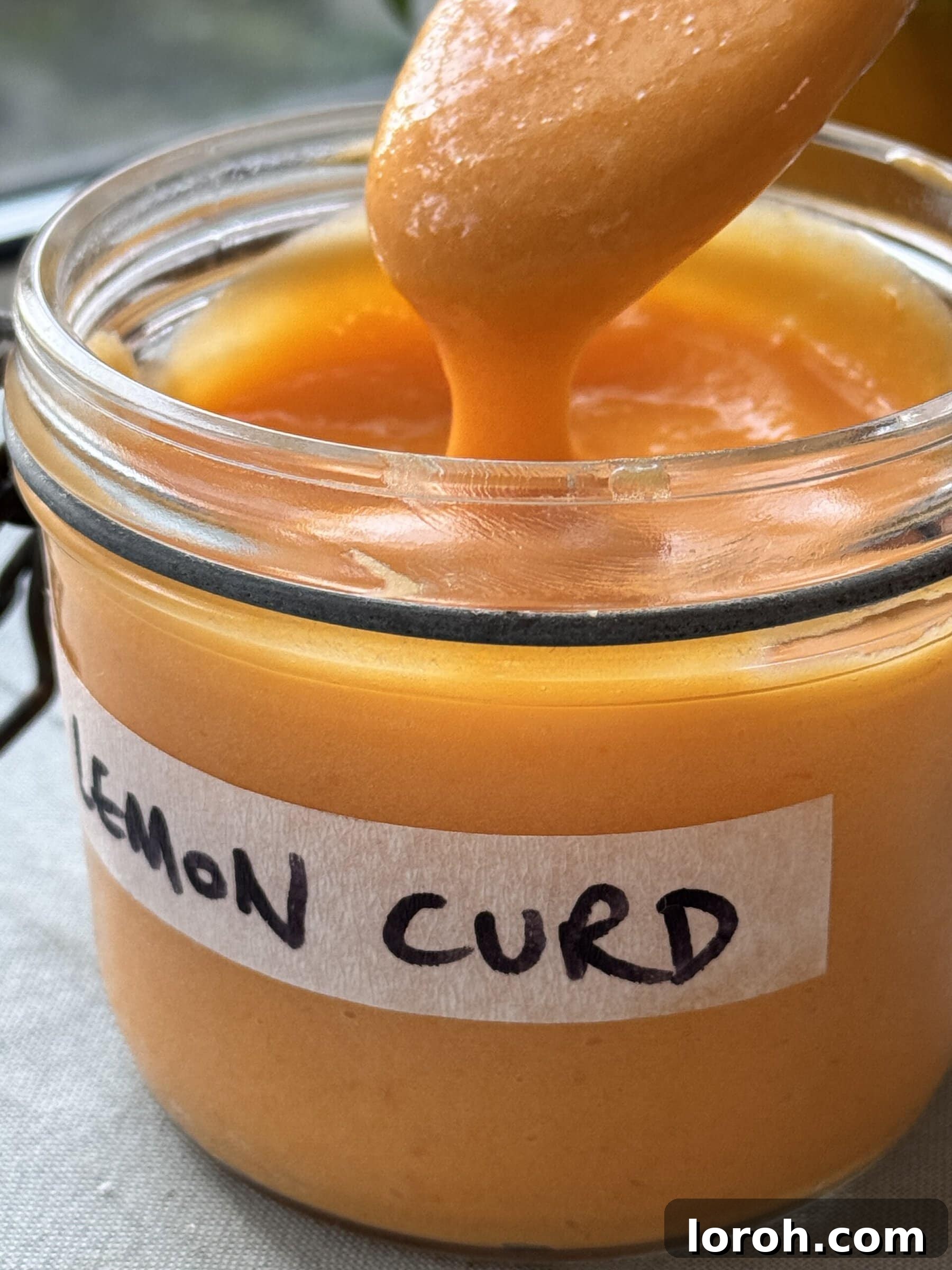 Homemade lemon curd stored beautifully in a glass jar, showcasing its smooth texture and vibrant yellow colour, ready for use.