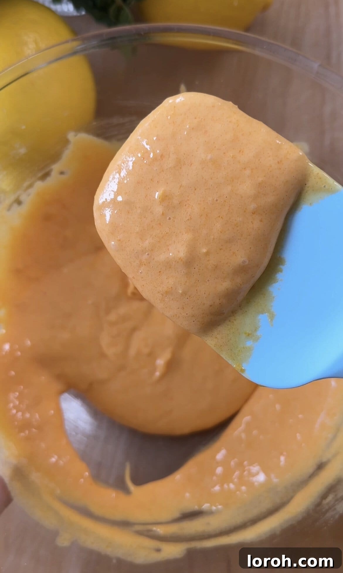 Close-up of the perfectly pale, thick, and foamy texture of the egg yolk and sugar mixture, showing proper aeration and emulsification.