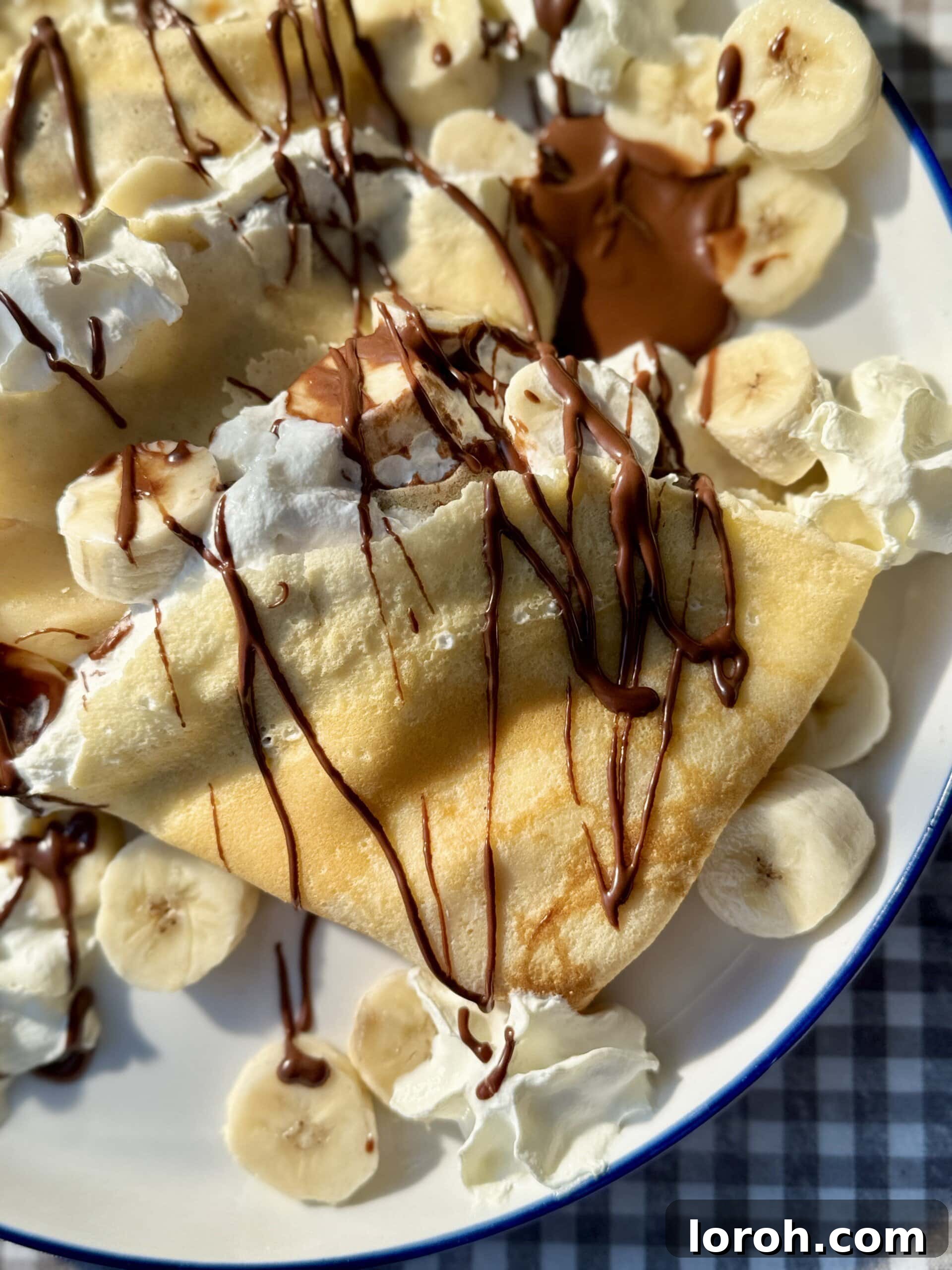 Golden Banana Crêpes 3 A single banana crepe elegantly folded into quarters, showcasing its thin, delicate texture, poised for delightful toppings.