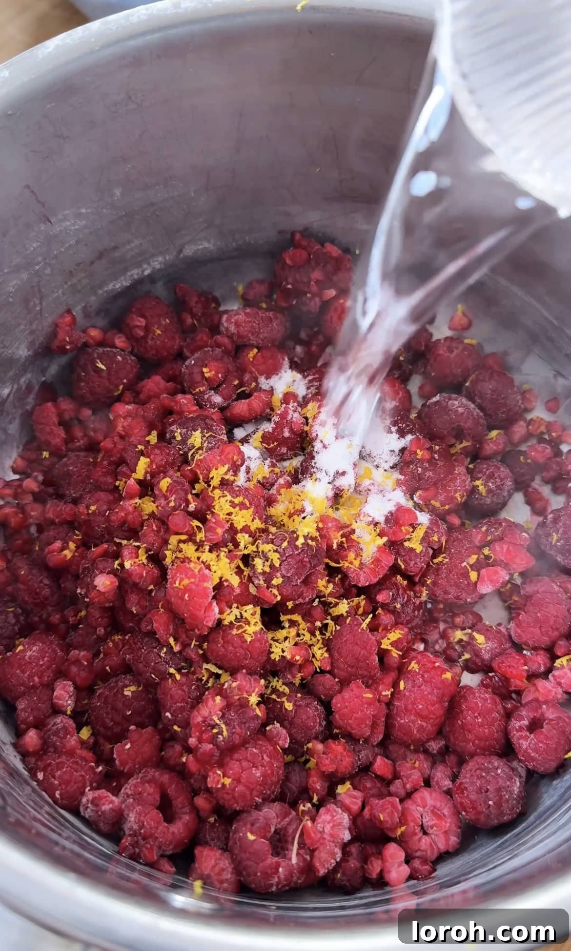 Raspberries, sugar, lemon zest in a saucepan, beginning to simmer for compote.