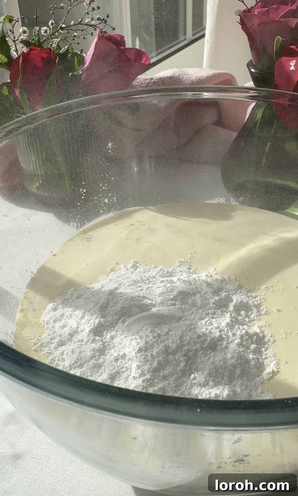 adding icing sugar to double cream in a bowl.