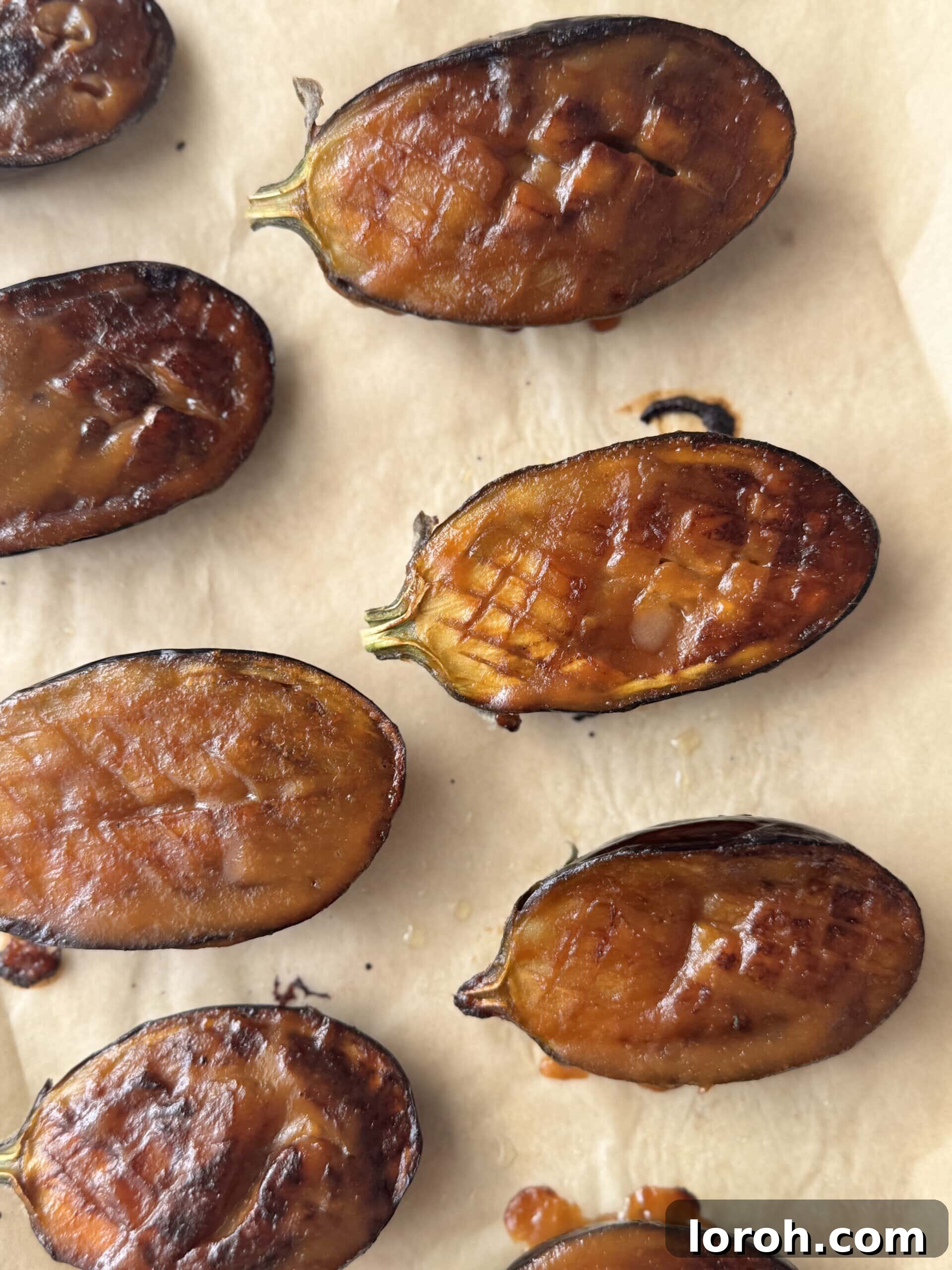 Roasted miso aubergine slices arranged on a baking tray.