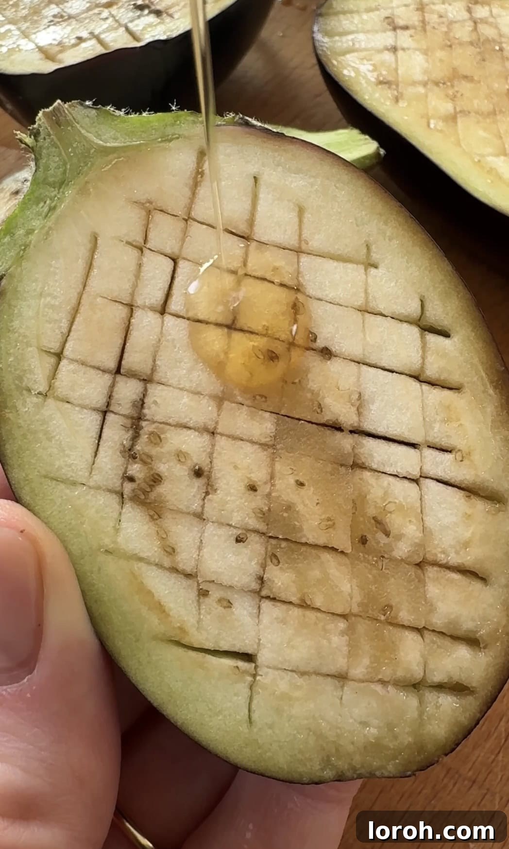 Brushing sesame oil onto aubergine.