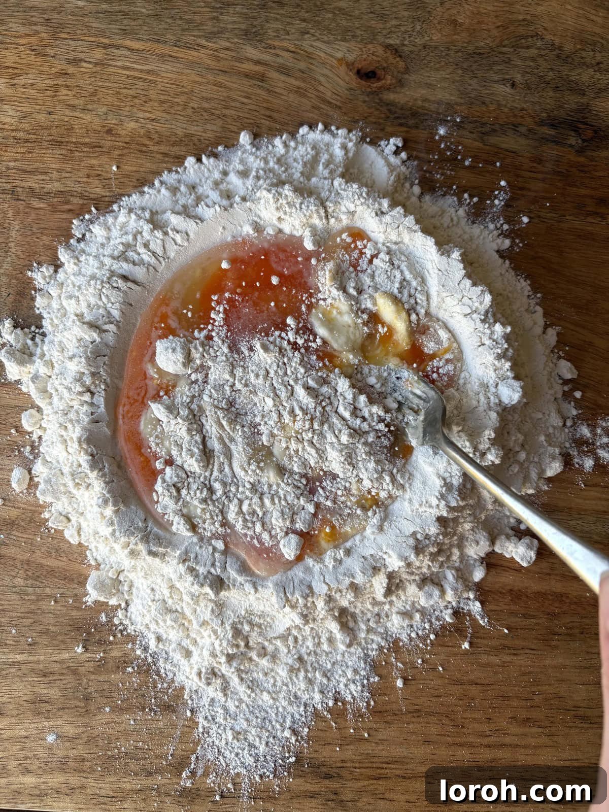 The Art of Homemade Pasta Dough 5 incorporating flour into the eggs using a fork.