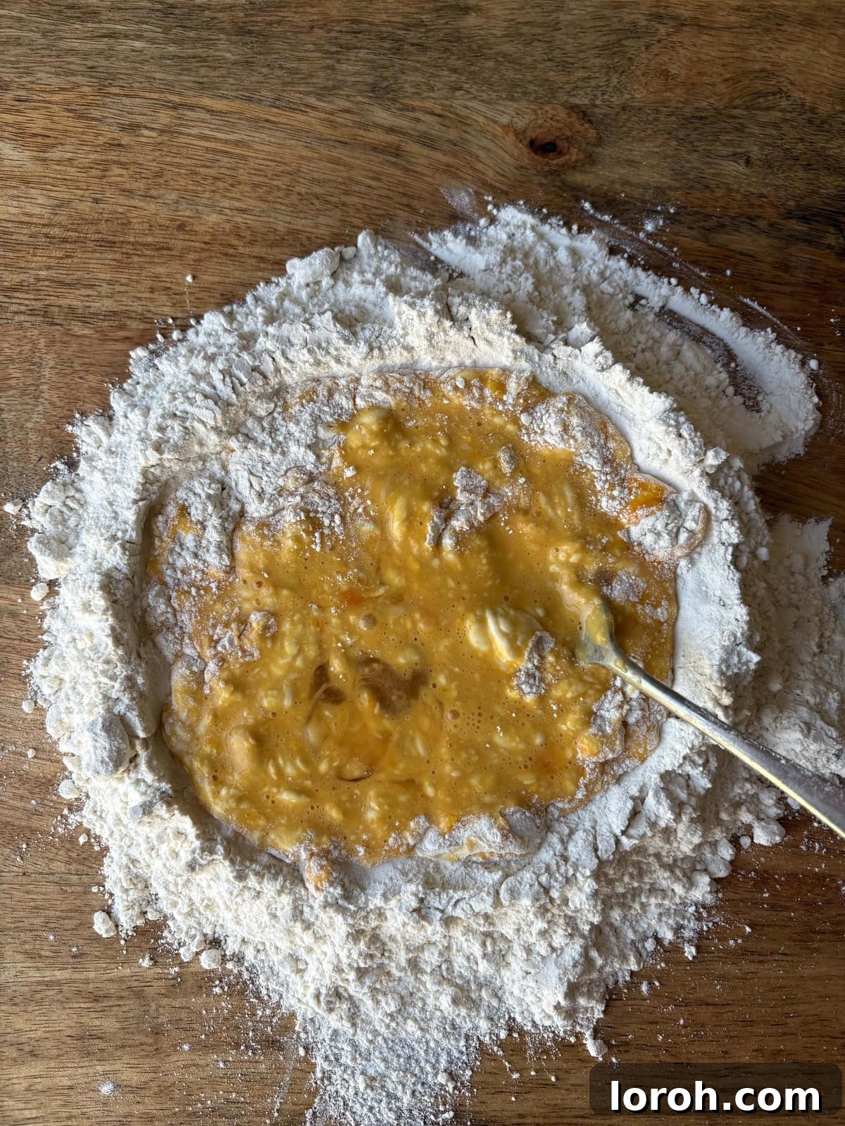 The Art of Homemade Pasta Dough 6 continuing to incorporate flour into the liquid egg mixture.