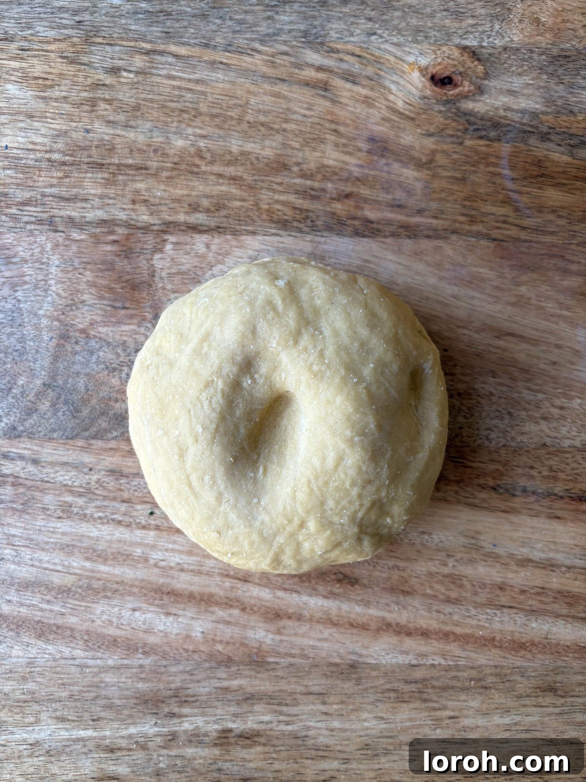 The Art of Homemade Pasta Dough 8 finger indenting freshly kneaded pasta dough, showing it springs back.