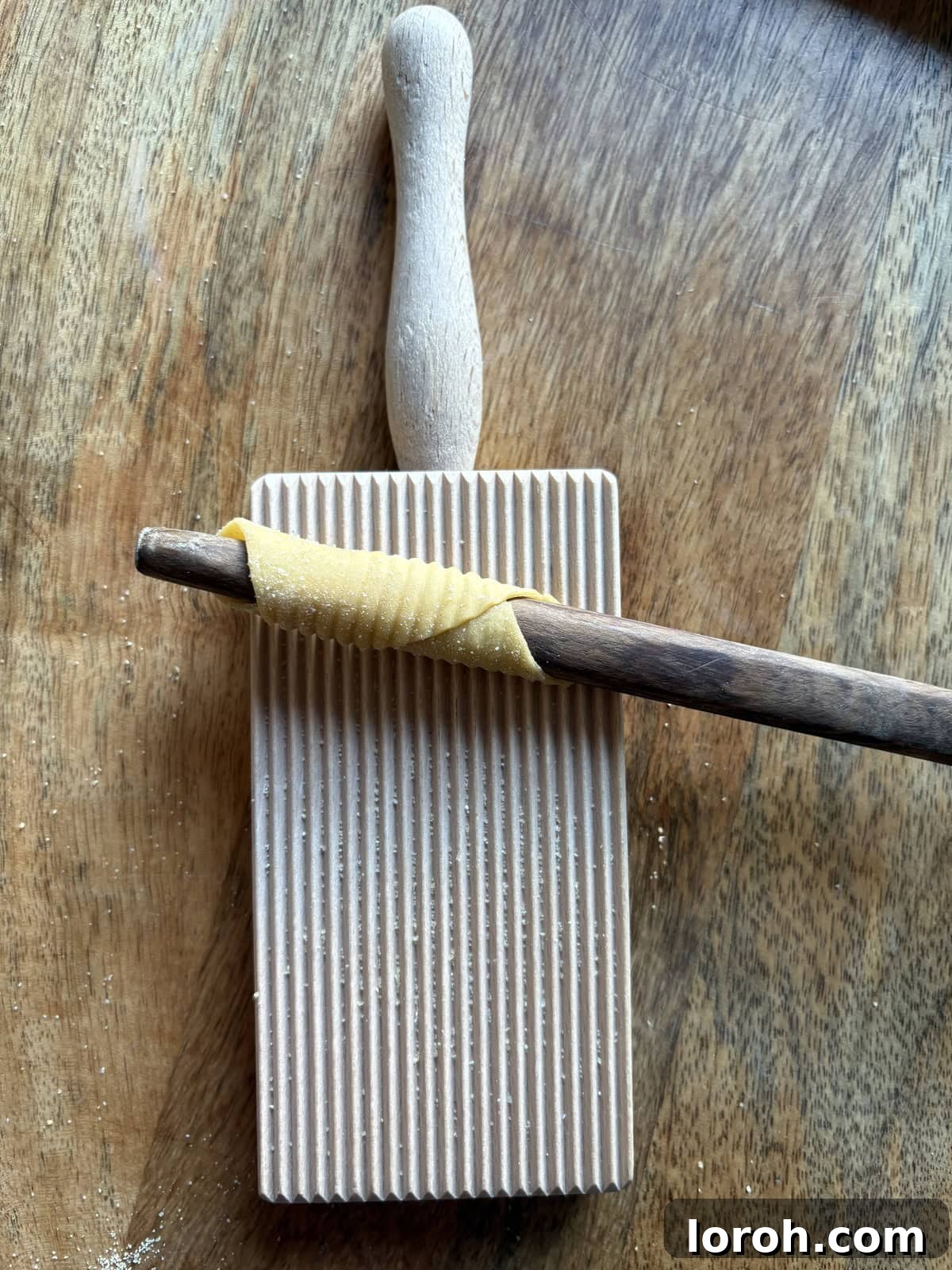 Pasta dough fully wrapped around the stick and ridged.