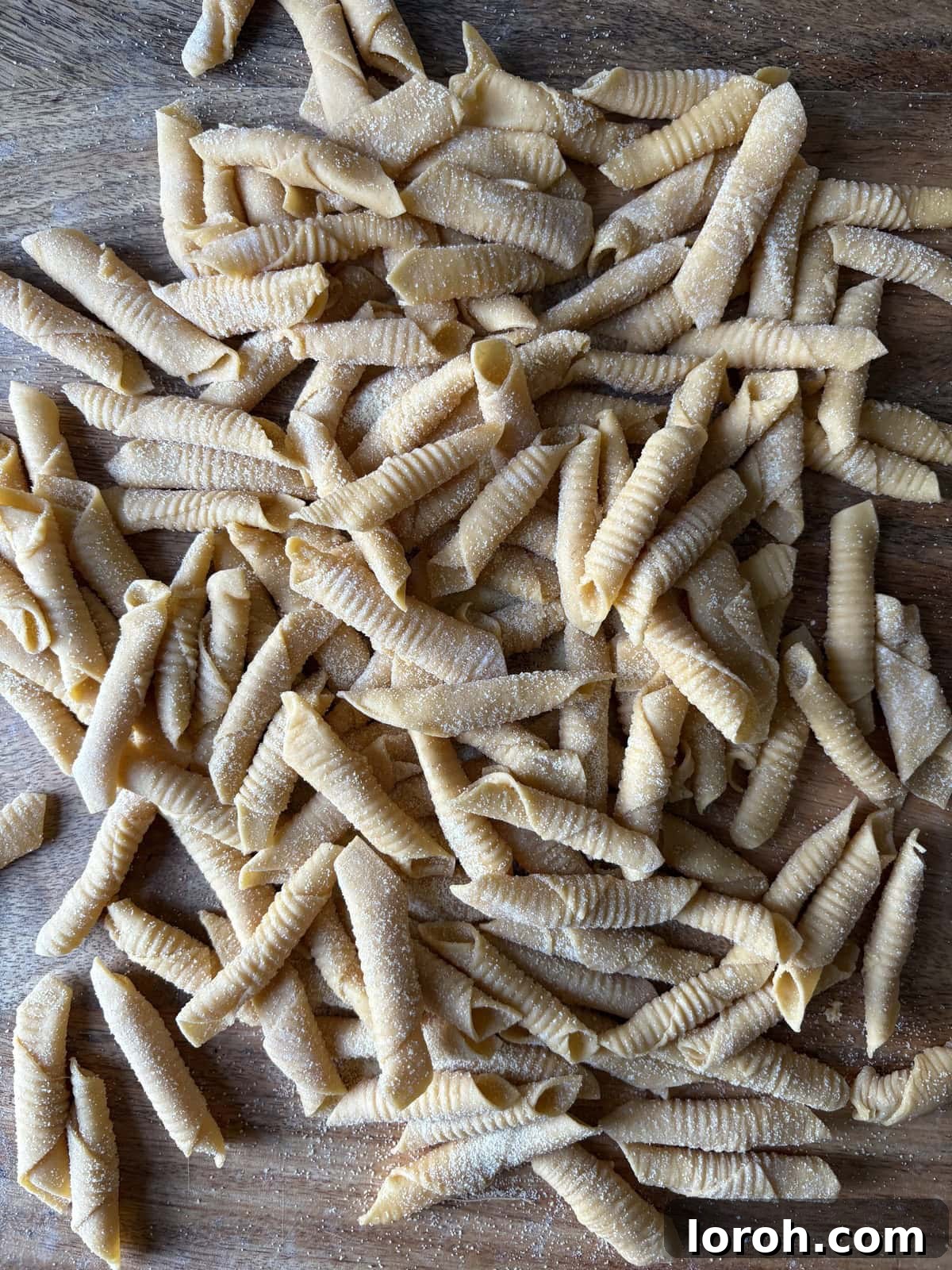 Finished garganelli pasta tubes on a baking tray.