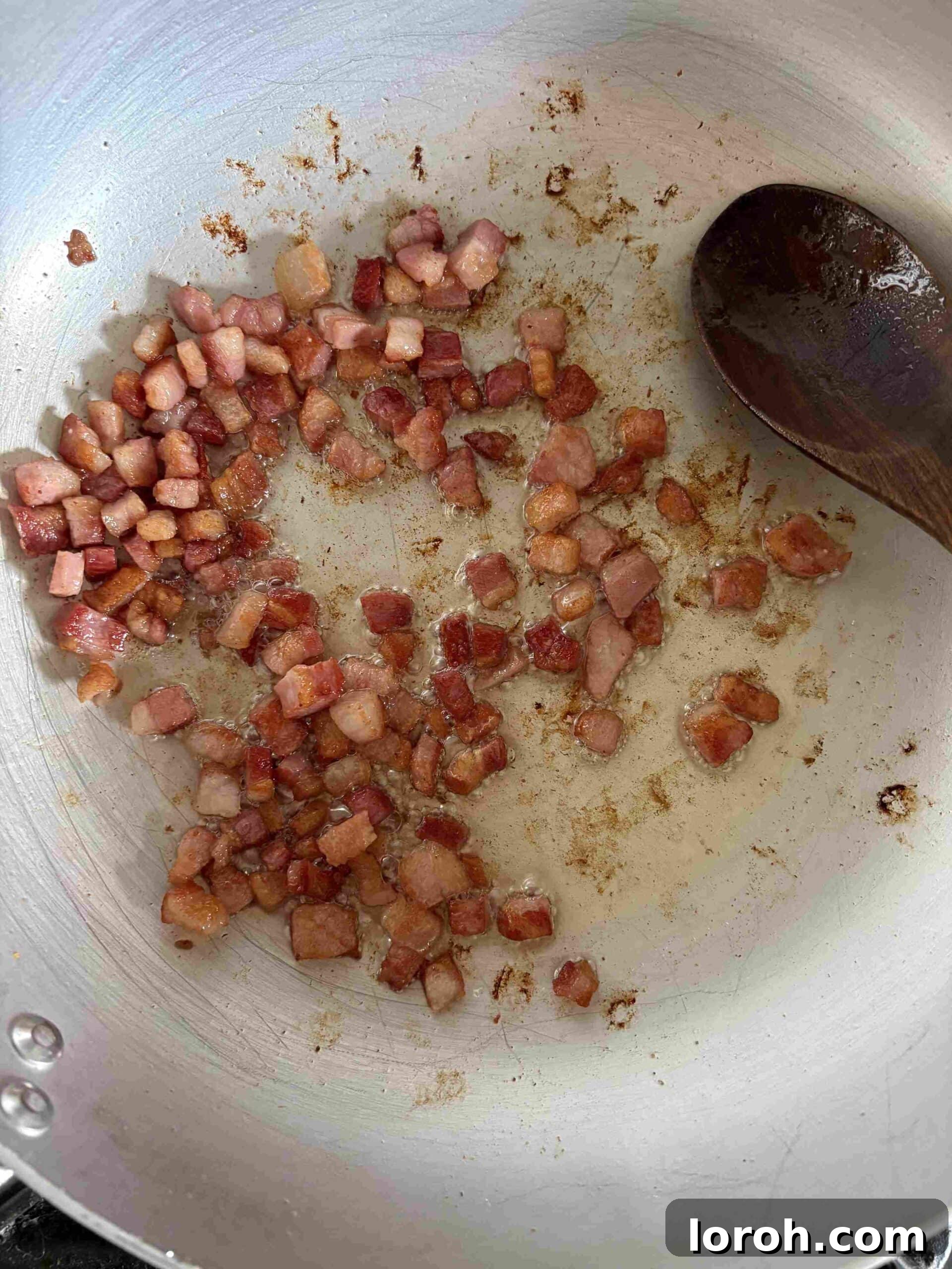 Guanciale Tomato Penne 5 Diced guanciale being dry-fried in a large non-stick pan, rendering out its fat to become crispy.