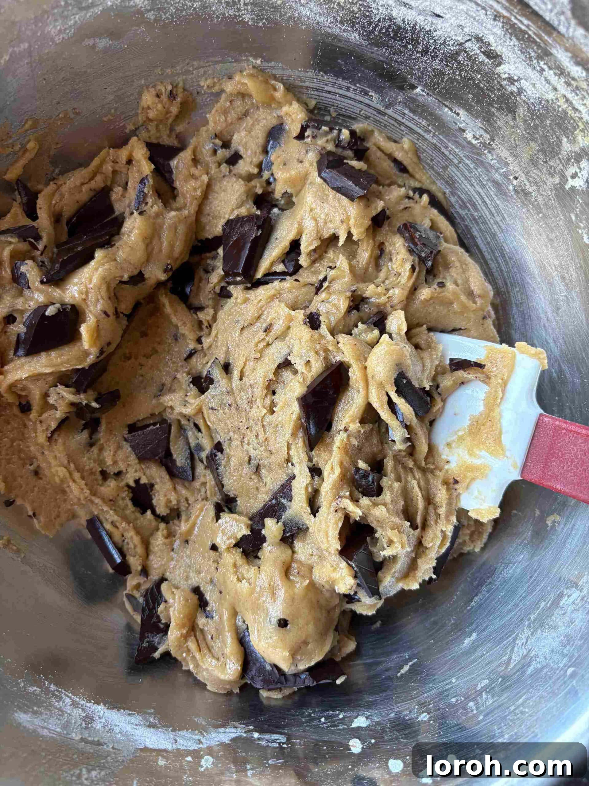 Ultimate Chocolate Chip Cookie Bars 13 Folding chocolate chunks into cookie dough.