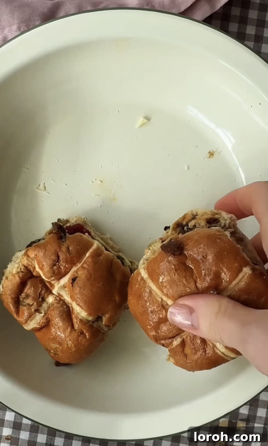 Image showing the hot cross bun sandwiches being arranged neatly in a buttered baking dish.