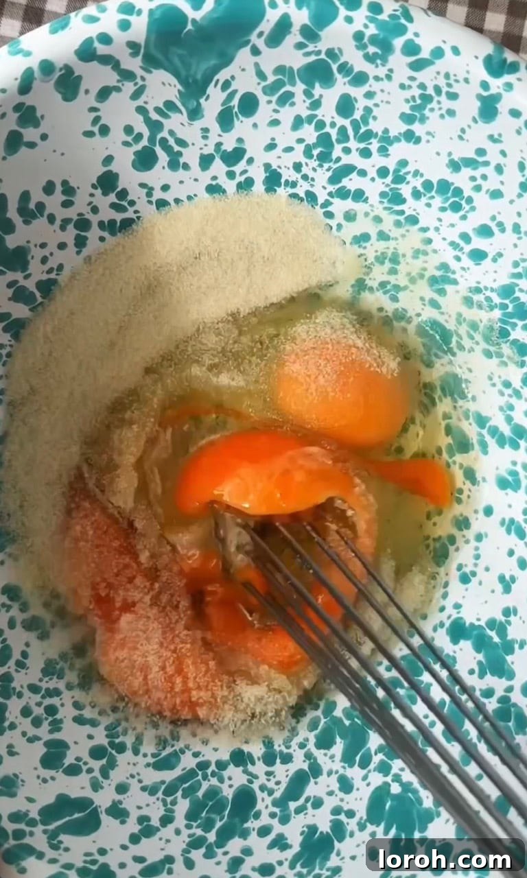 Image showing eggs and caster sugar being whisked together in a large bowl.