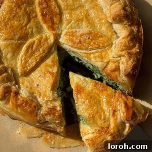 Torta Pasqualina with a slice removed, revealing the creamy filling and whole eggs.