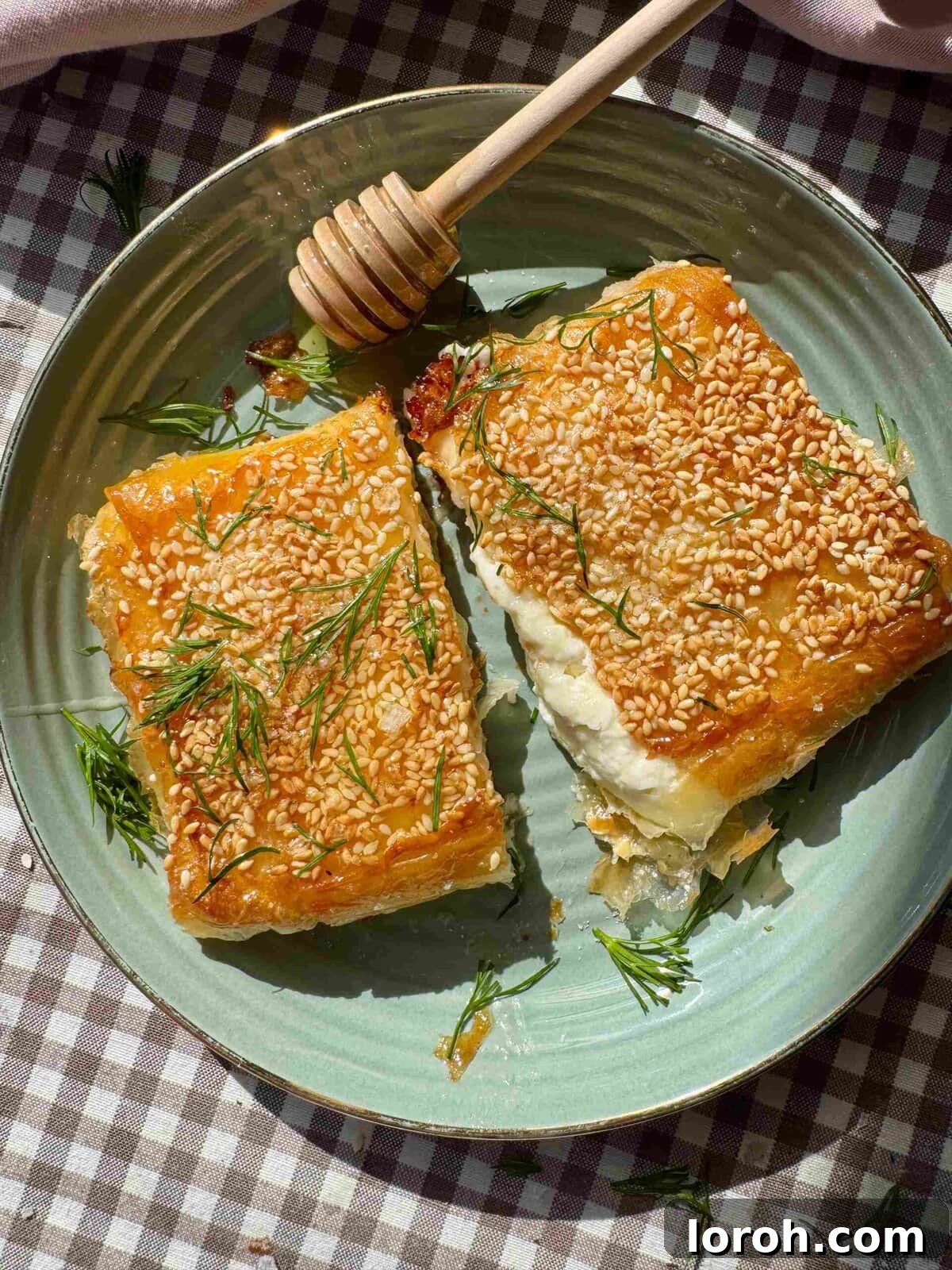 Flaming Feta Saganaki 2 Crispy Feta Saganaki with Honey and Sesame on a plate, garnished with fresh herbs
