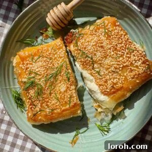 Flaming Feta Saganaki 12 Feta saganaki cut in half on a green plate with honey and dill.