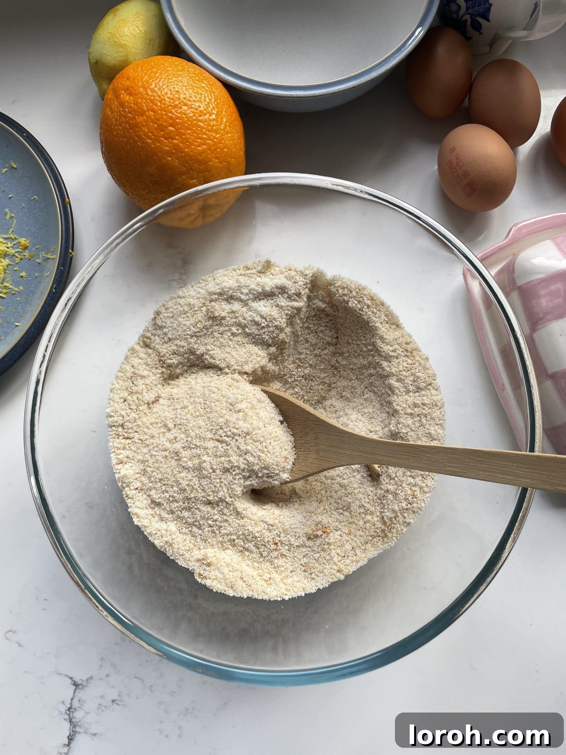 Dry ingredients being mixed together in a clear glass mixing bowl for the Tunisian Orange Cake.
