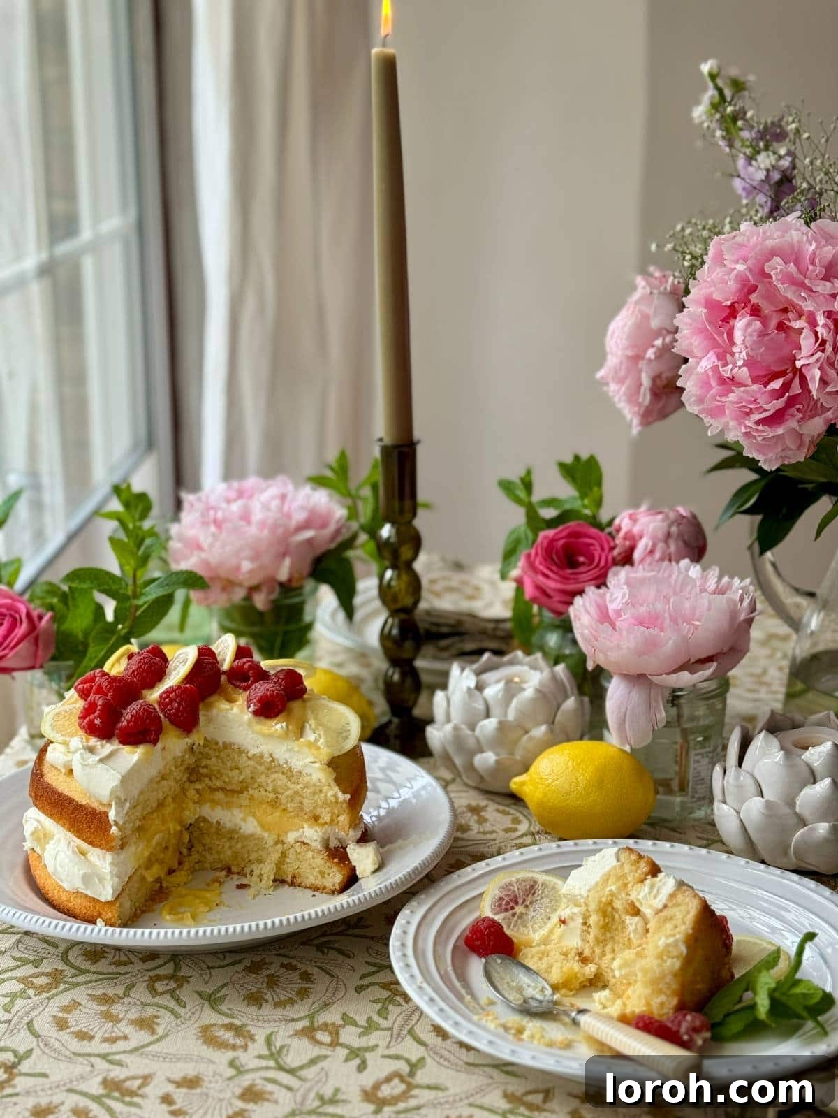 A delectable slice of lemon curd cake on a small plate, with the full cake visible in the background, showcasing its inviting layers.