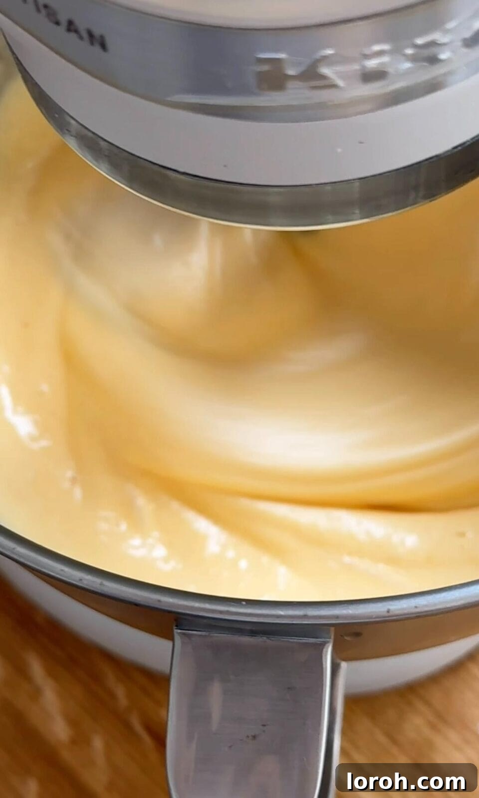 Eggs and sugar being beaten in a stand mixer until pale and thick.