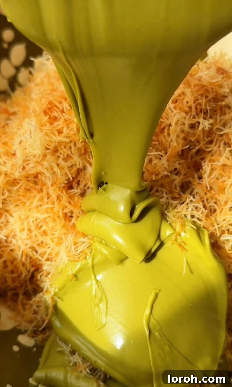Mixing toasted kataifi with pistachio cream to create the filling.