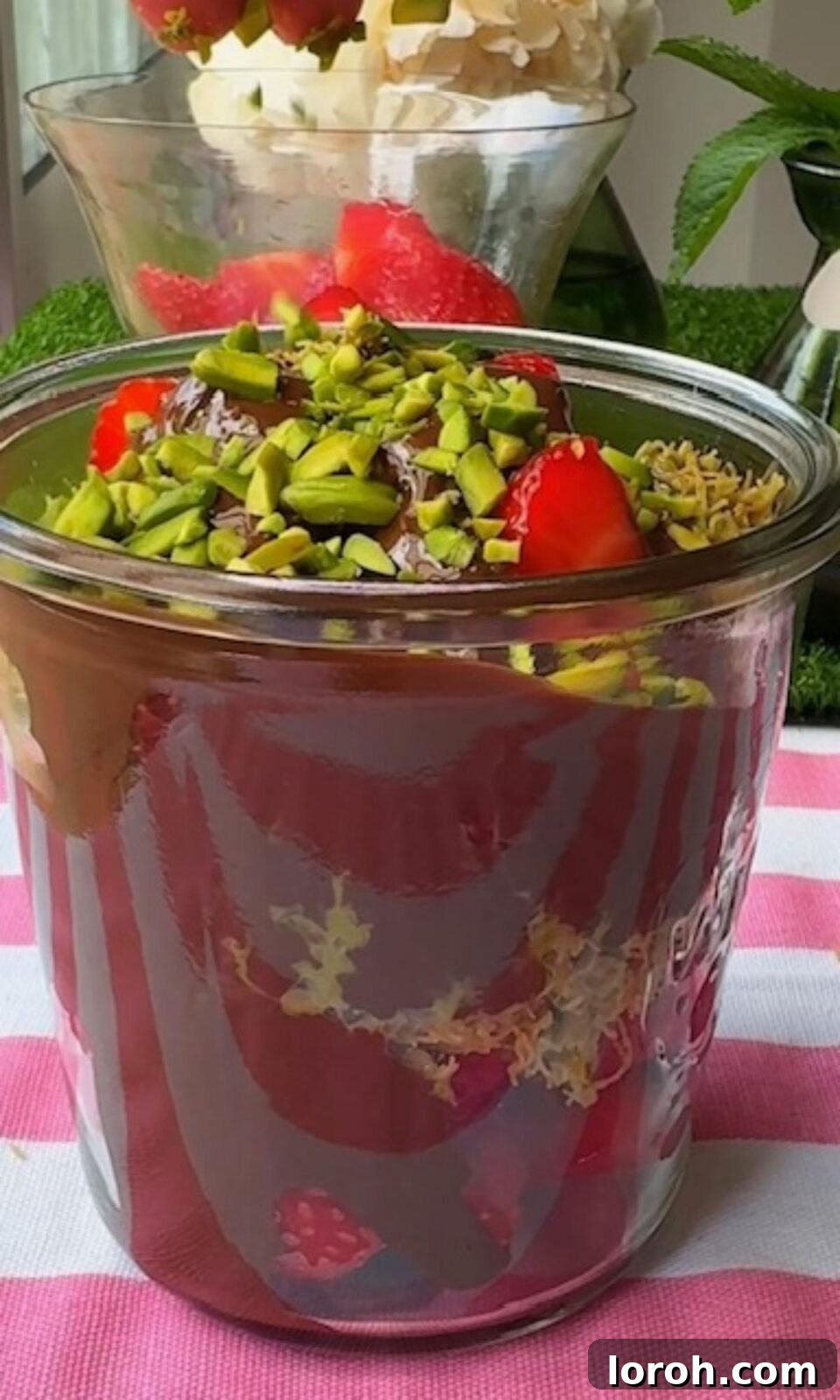 Topping the Dubai chocolate strawberry dessert with slivered pistachios.
