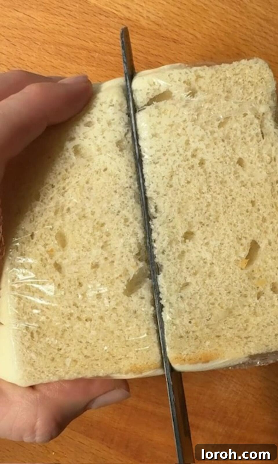 Slicing a chilled Japanese strawberry sandwich (Ichigo Sando) to reveal its beautiful cross-section.