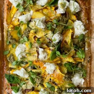 A freshly baked courgette tart with melted mozzarella and pesto drizzle.