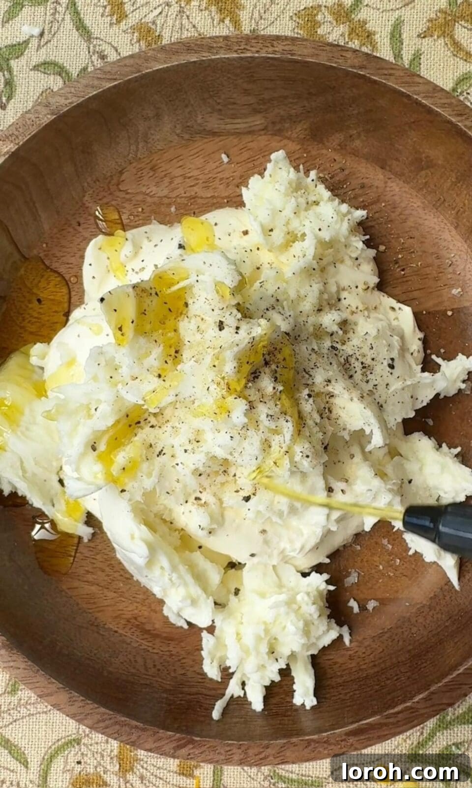 Golden Zucchini Tart 6 A bowl containing torn mozzarella and crème fraîche being mixed together with a spoon until smooth and creamy.