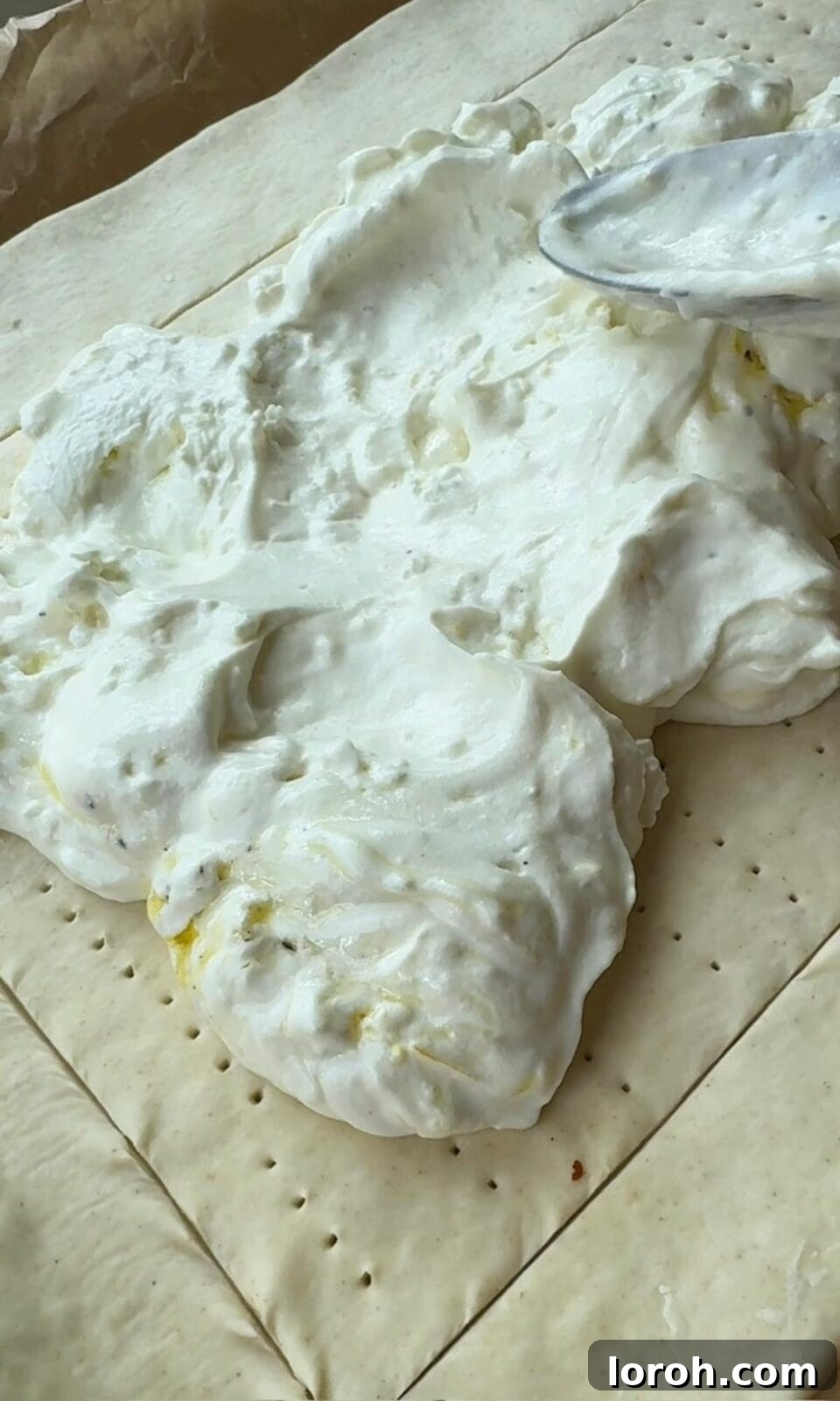 Golden Zucchini Tart 8 The creamy mozzarella and crème fraîche mixture being smoothed over the pricked center of the puff pastry, leaving the scored border clear.