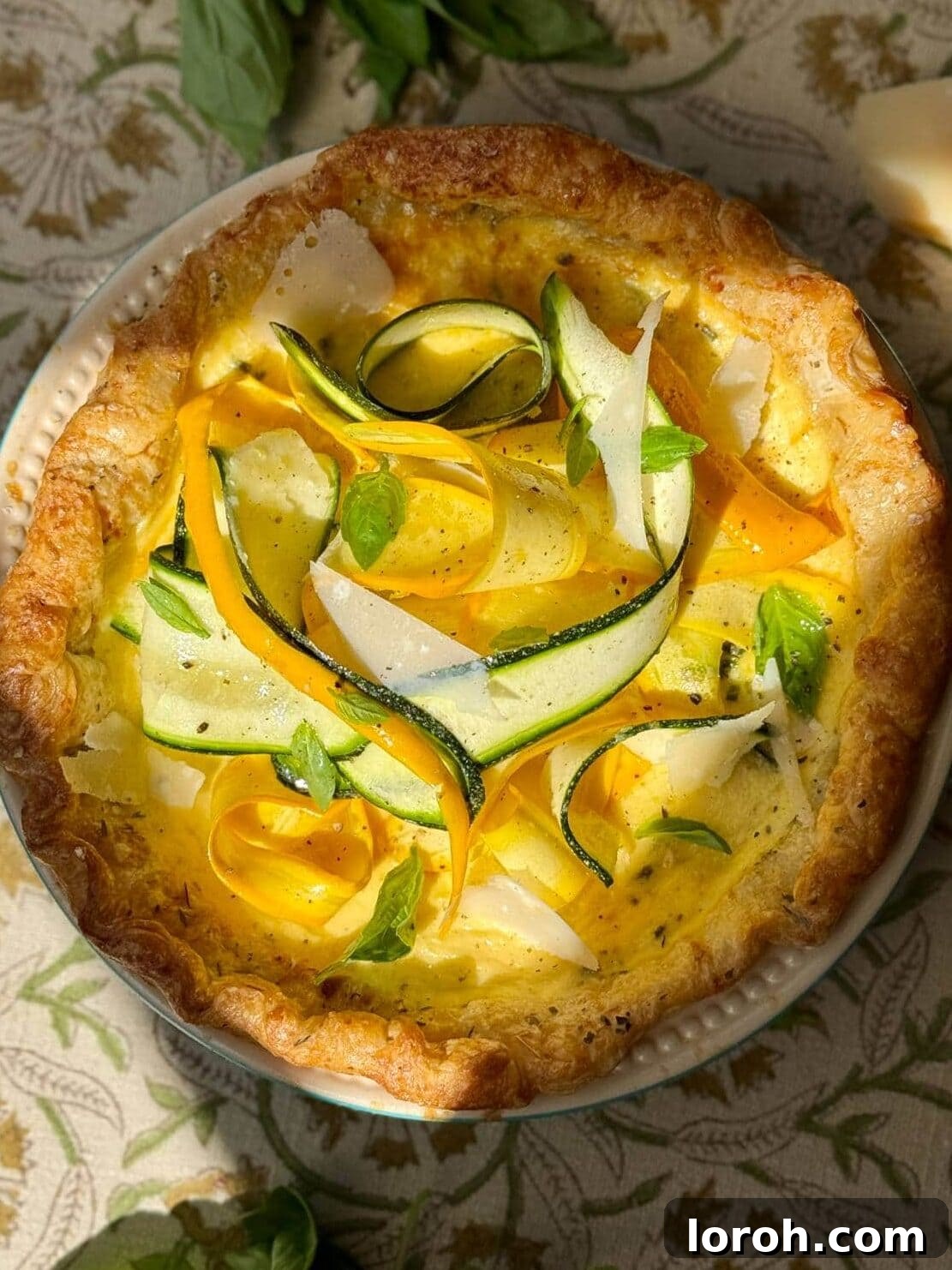 A perfectly baked golden-brown courgette quiche on a pristine white plate, showcasing its vibrant filling and flaky crust.