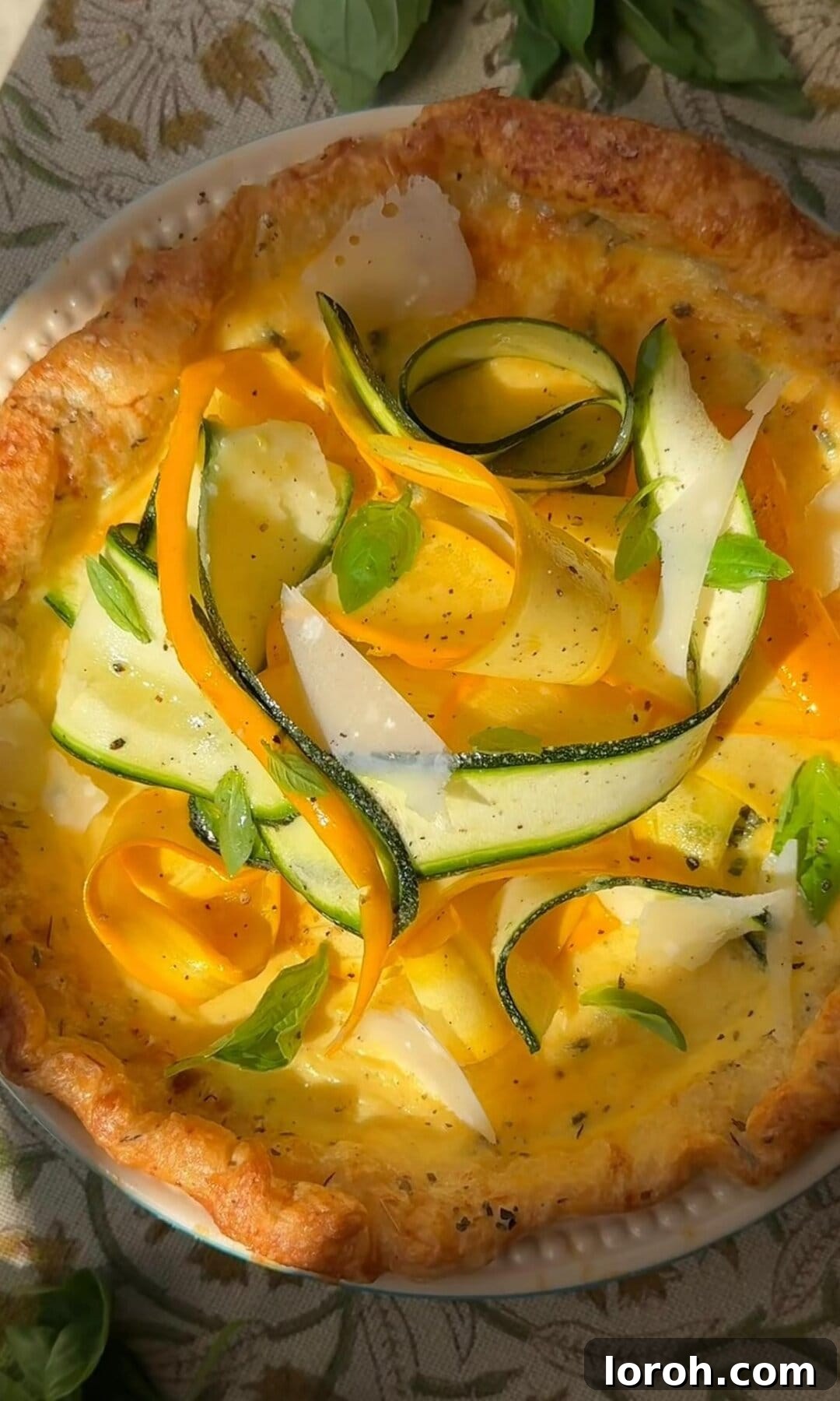 Arranging the fresh courgette ribbon salad artistically on top of a baked courgette quiche.