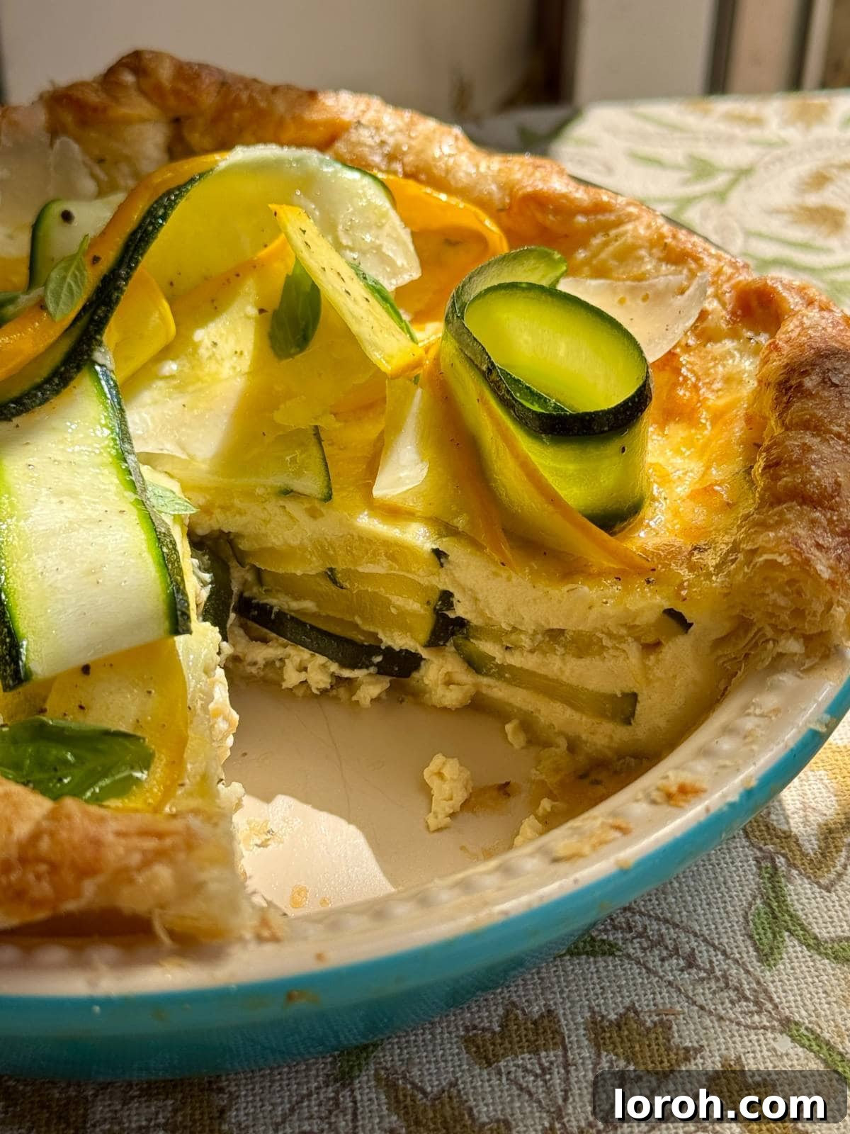 Garden Zucchini Quiche 3 A slice of courgette quiche removed from a whole quiche, showing the fluffy egg and zucchini filling.