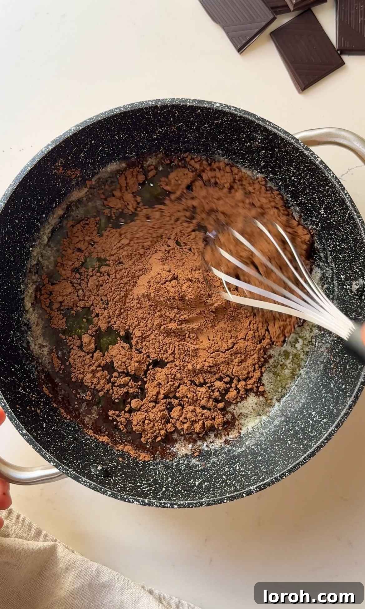 Decadent Chocolate Fudge Cake 9 Melting unsalted butter and stirring in cocoa powder in a small saucepan for the chocolate icing base.