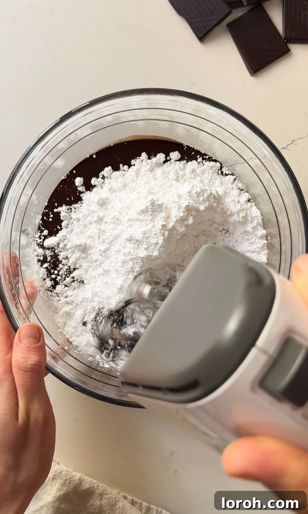 Decadent Chocolate Fudge Cake 10 Mixing sifted icing sugar into the chocolate butter mixture on low speed in a stand mixer.