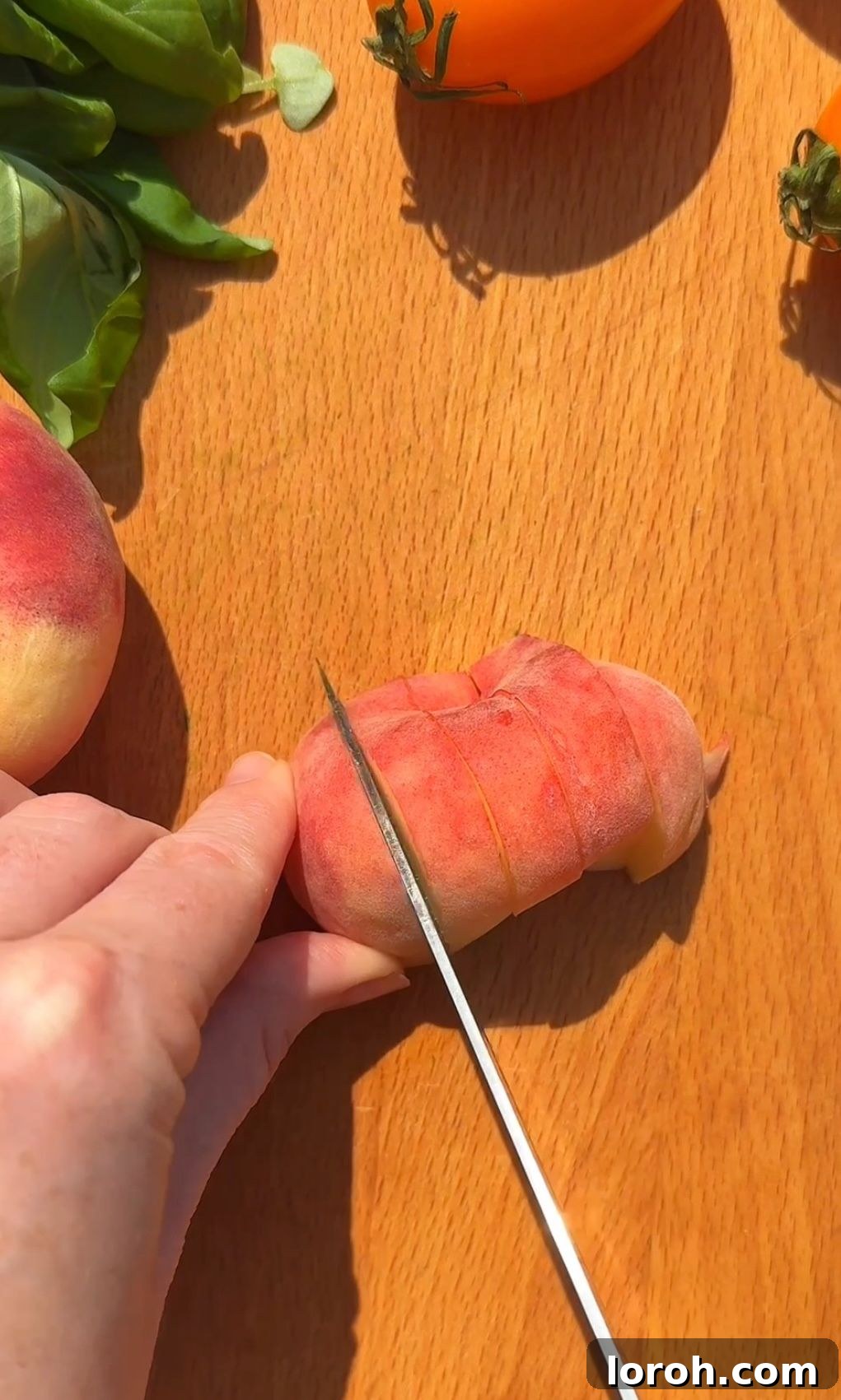 Creamy Burrata and Sweet Peach Salad 4 A peach being carefully sliced on a cutting board, ready for the salad.