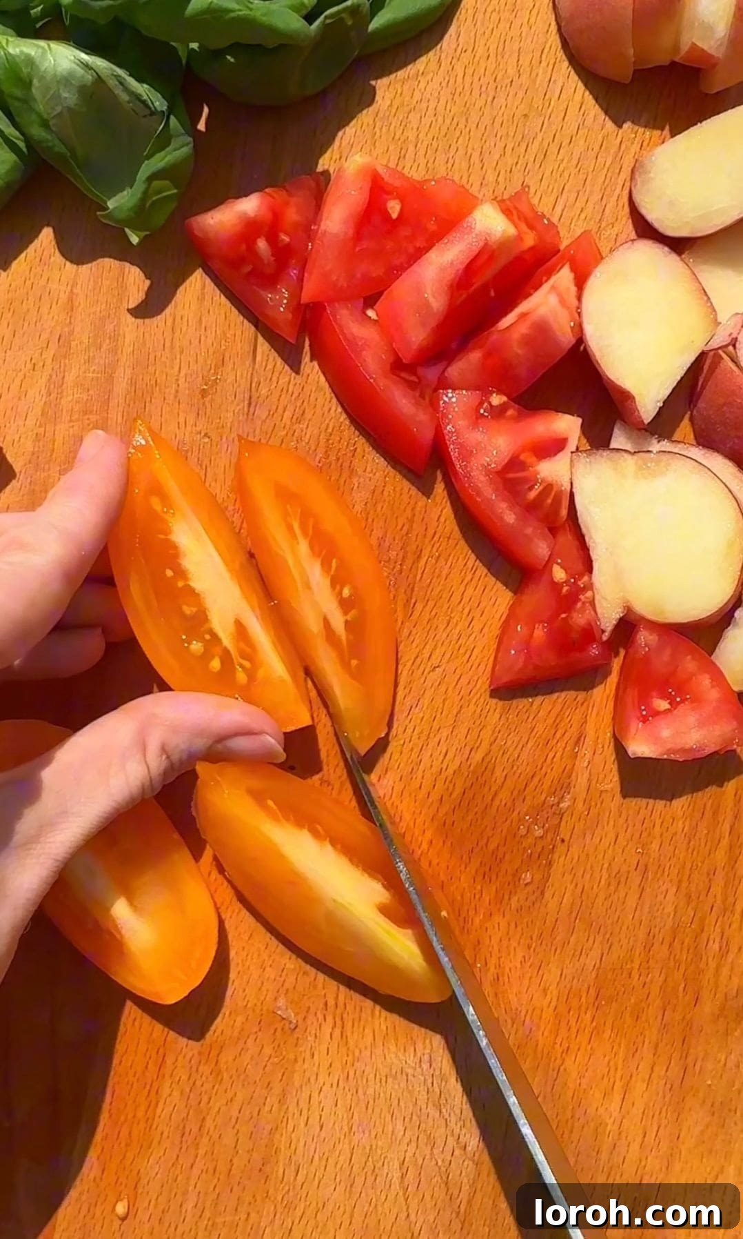 Creamy Burrata and Sweet Peach Salad 5 Fresh tomatoes being sliced on a cutting board, ready to be added to the salad.
