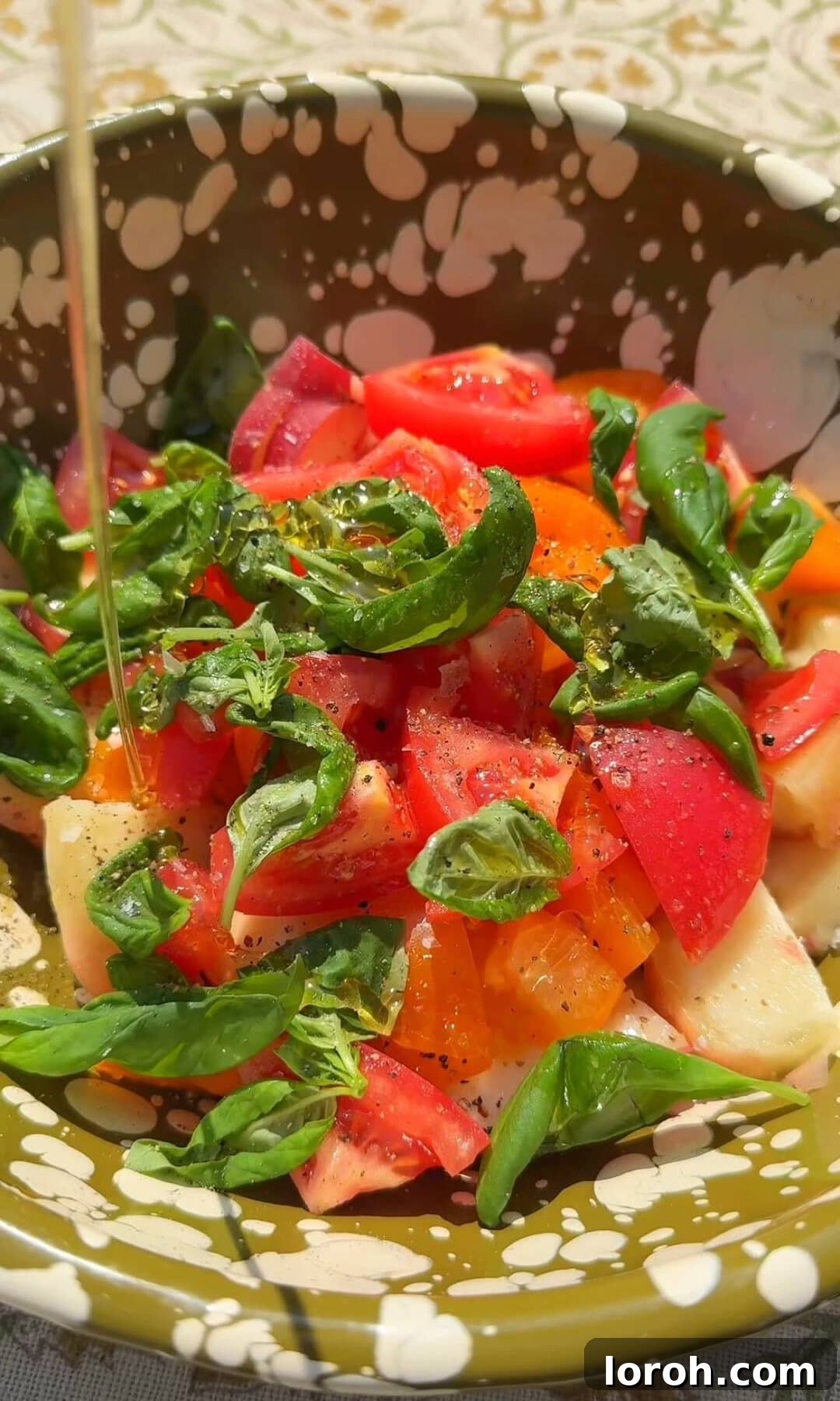 Creamy Burrata and Sweet Peach Salad 6 A bowl with sliced tomatoes and peaches being dressed with olive oil, red wine vinegar, and honey.