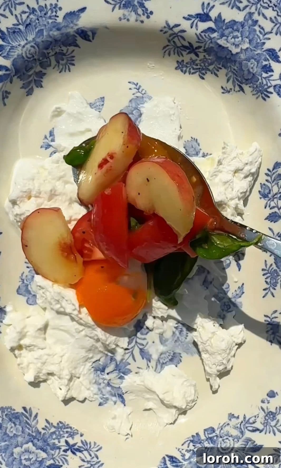 Creamy Burrata and Sweet Peach Salad 7 Arranging the burrata and peach salad on a serving plate, with creamy burrata spread at the base and fruit piled on top.