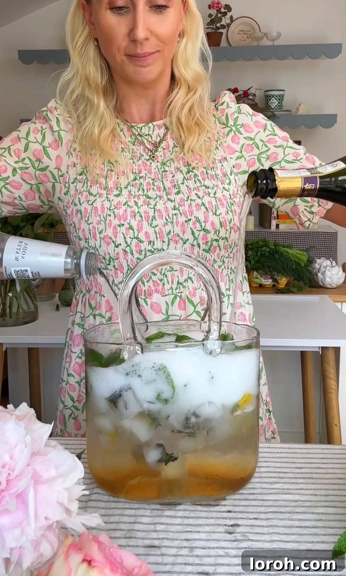 Topping a Hugo Spritz with Prosecco and soda water, creating fizz.