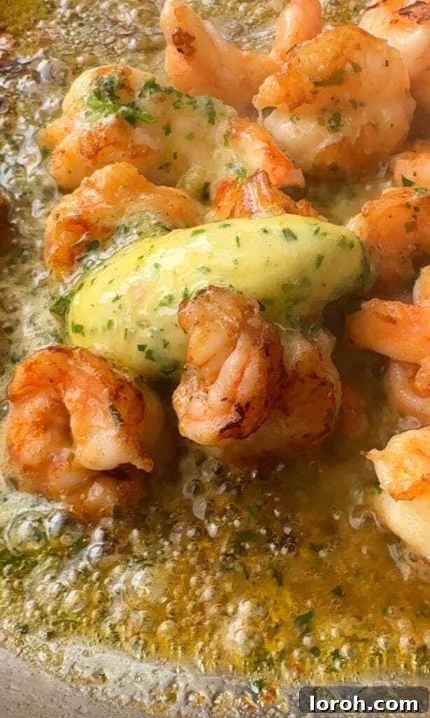 Fast Cowboy Butter Fix 5 Juicy prawns being sautéed in a pan, coated in the glossy, herb-flecked cowboy butter, ready to be served.