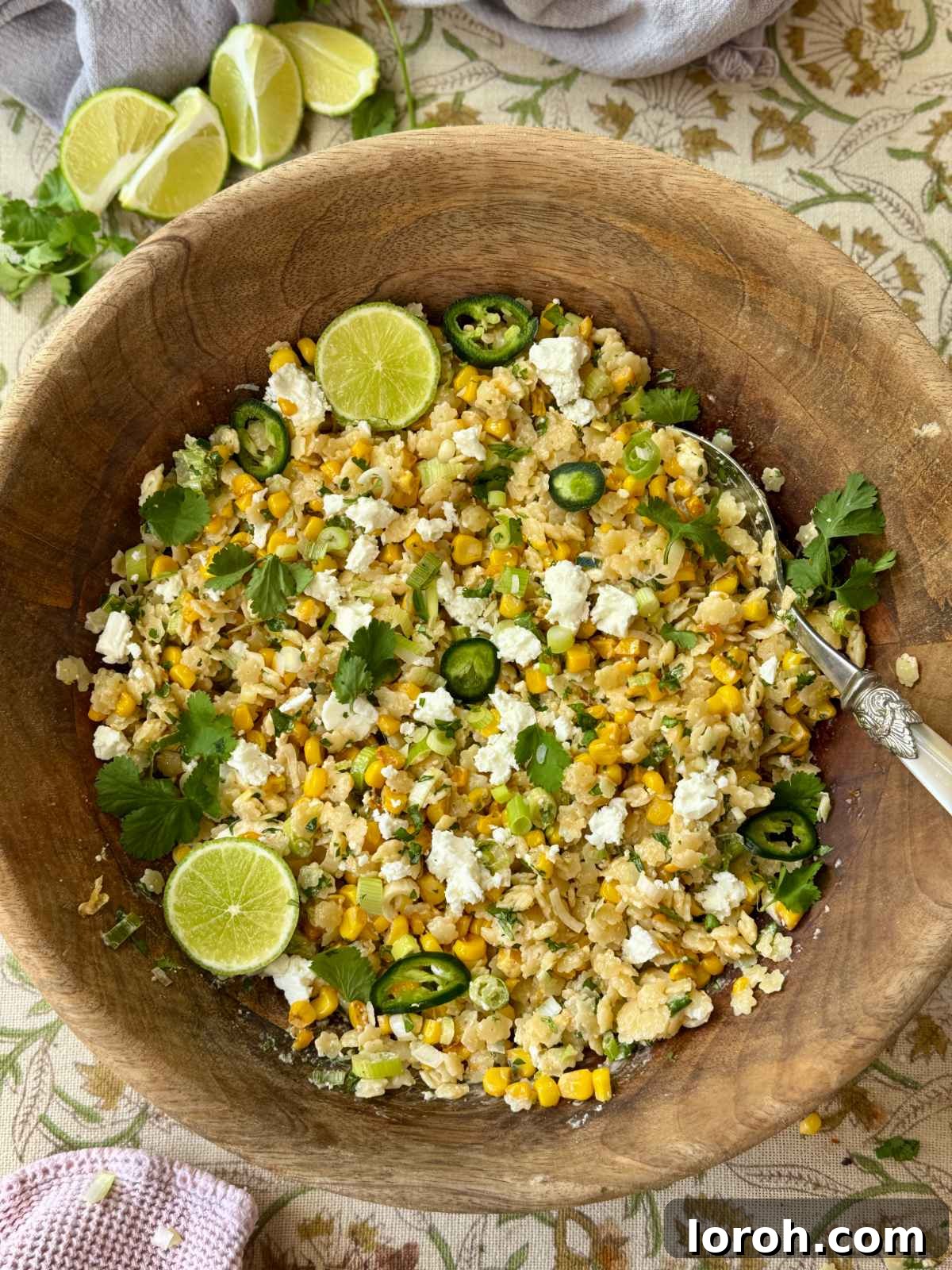 Vibrant Pastina Salad with Smoky Corn and Tangy Feta 2 pastina salad in a wooden bowl with lime slices and feta, ready to serve.