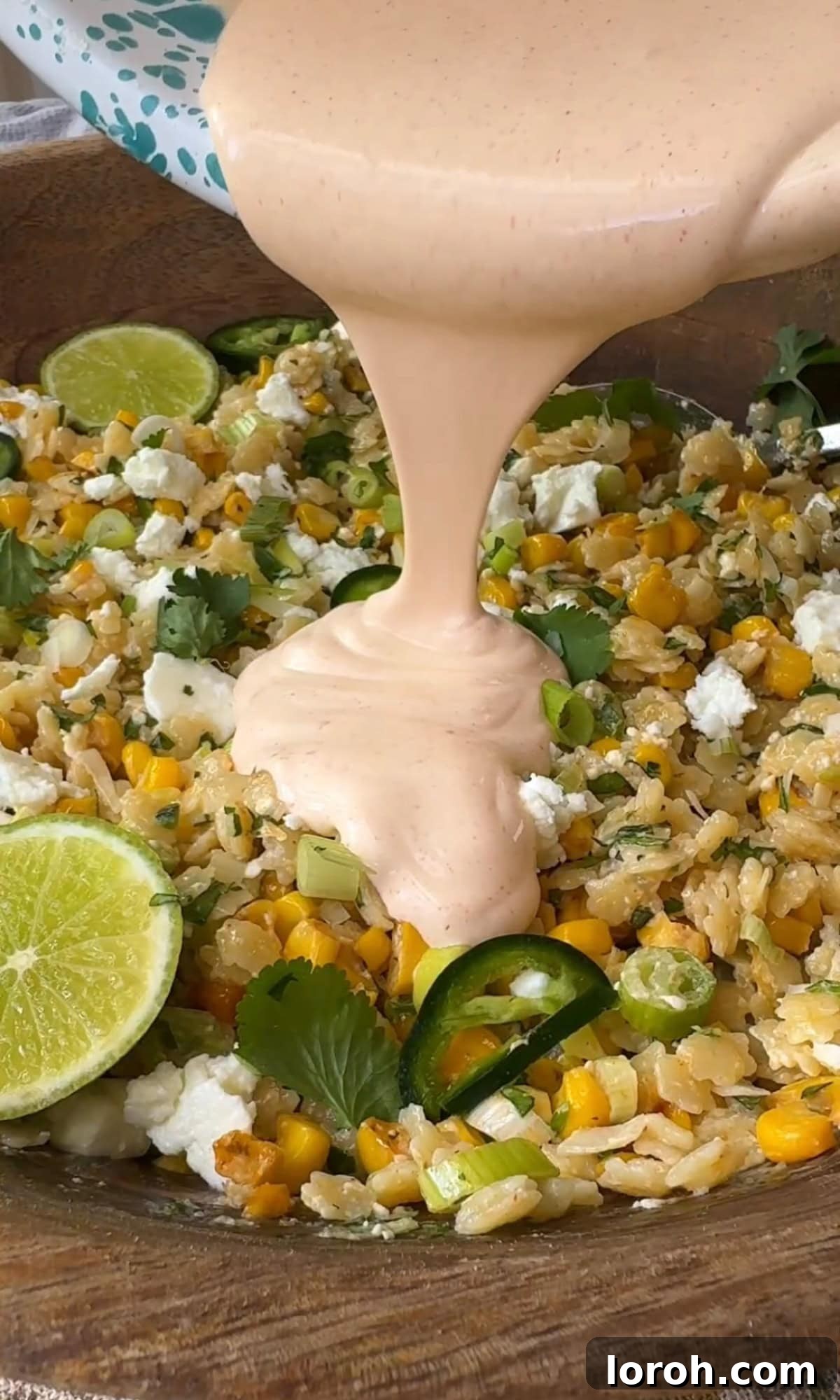 Vibrant Pastina Salad with Smoky Corn and Tangy Feta 8 pouring the creamy dressing over the pastina salad ingredients.